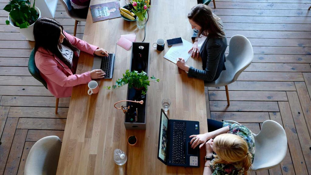 a group of women sitting at a table with laptops property deed abstract of title title abstractor