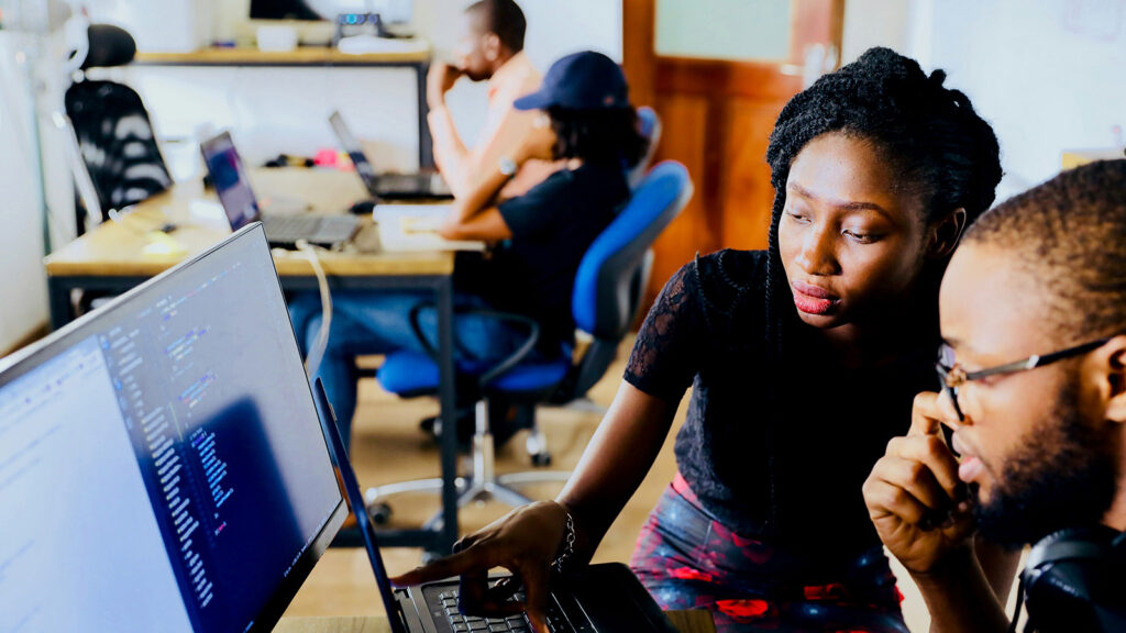 a woman sitting at a desk using a laptop JSON