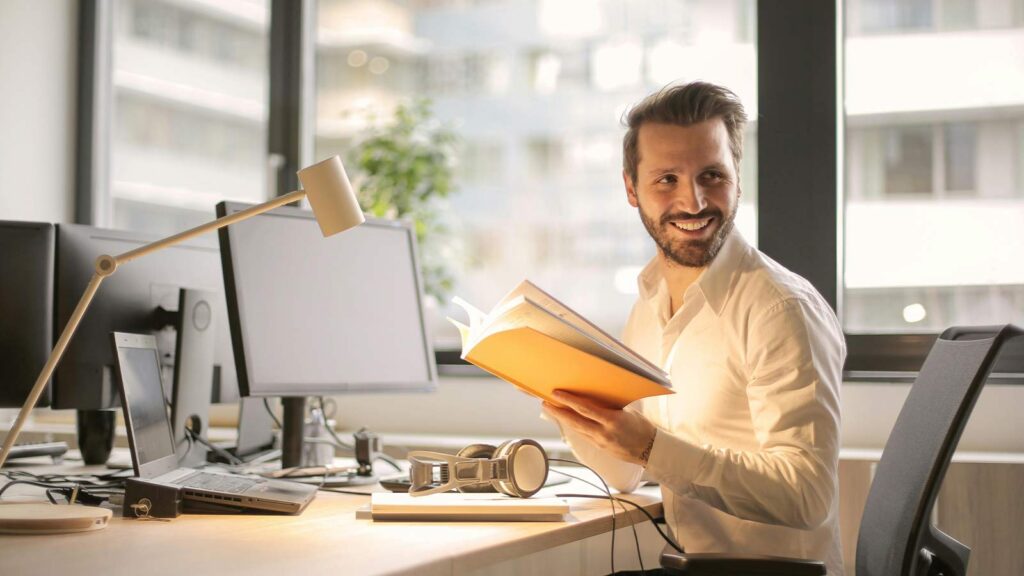 a man holding a book fast title search