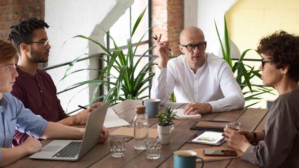 a group of people sitting around a table discussing title report