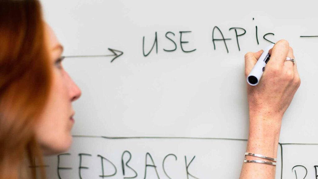 a woman writing on a whiteboard abstract of title