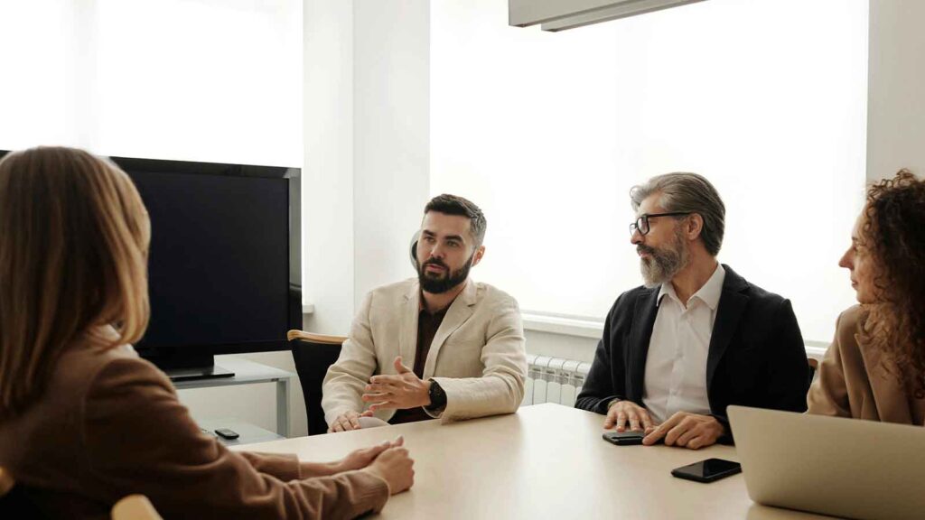 a group of men sitting at a table Same-Day-Title-Search