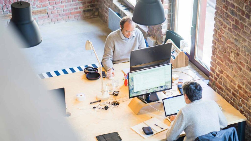 a group of people sitting at a table with computers mortgage loan lenders