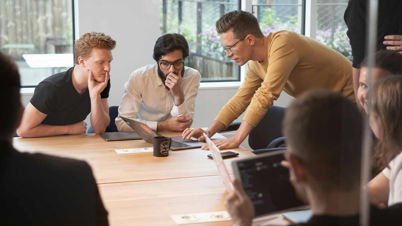 Group collaborating around a table. Lien-Search