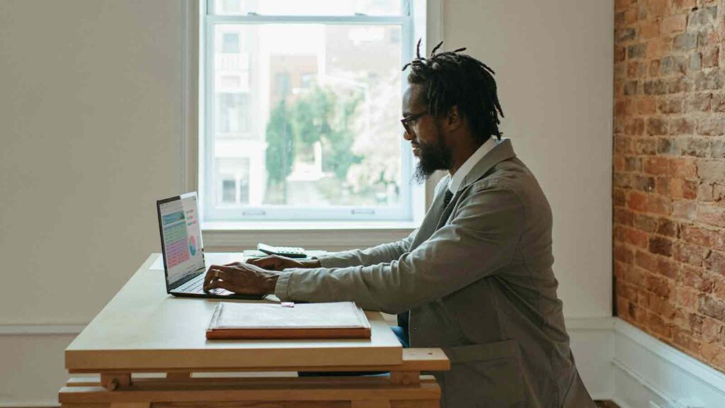 Person working at a wooden desk. title search software