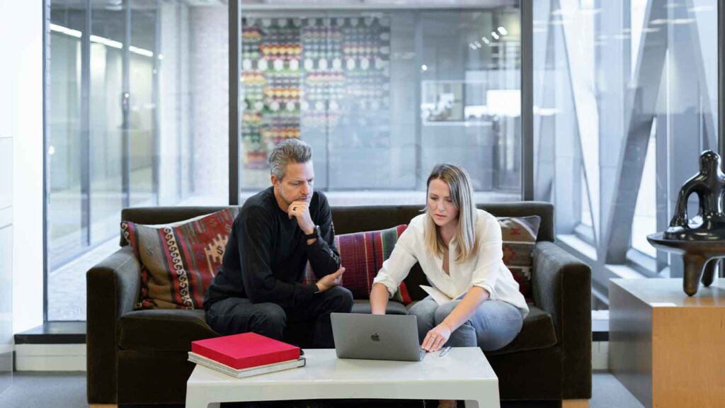 Two people collaborating on a laptop. Webhook